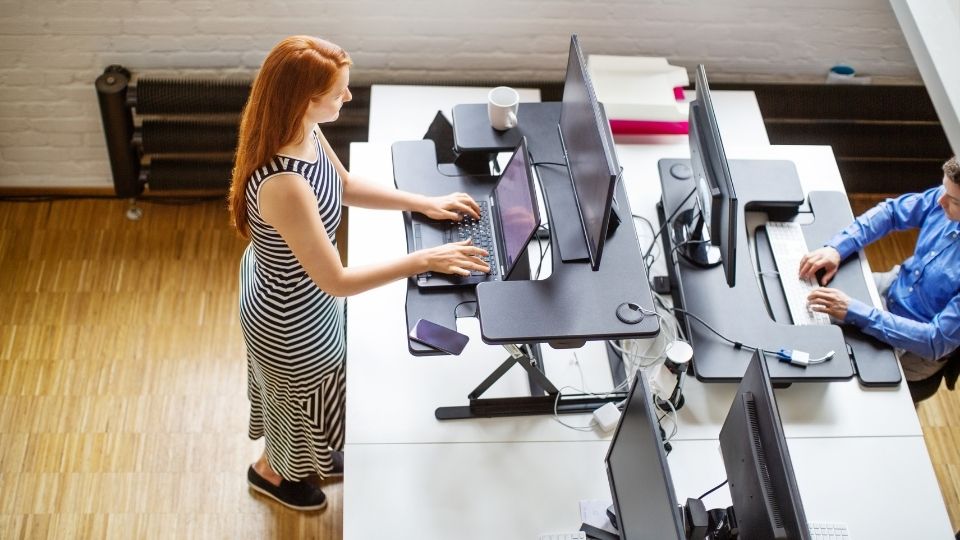 woman using standing desk at her workspace